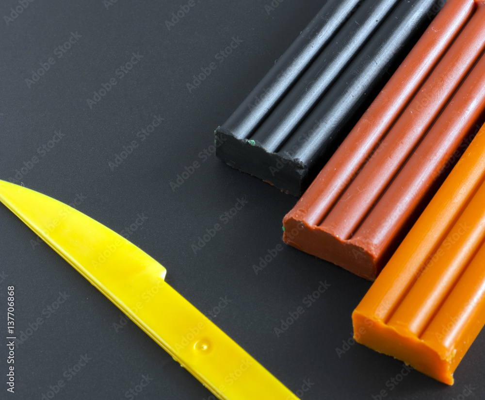 Colored Plasticine and knife on black background Colored Plasticine and knife on black background