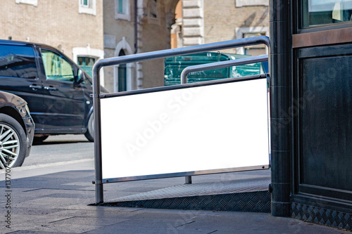 Photography Information booth with blank billboard advertising panel on a street in the city Rome over blurred traffic on the road
