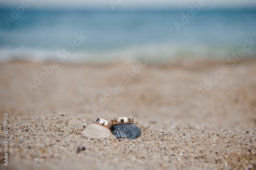 Photos of wedding rings on sand at beach