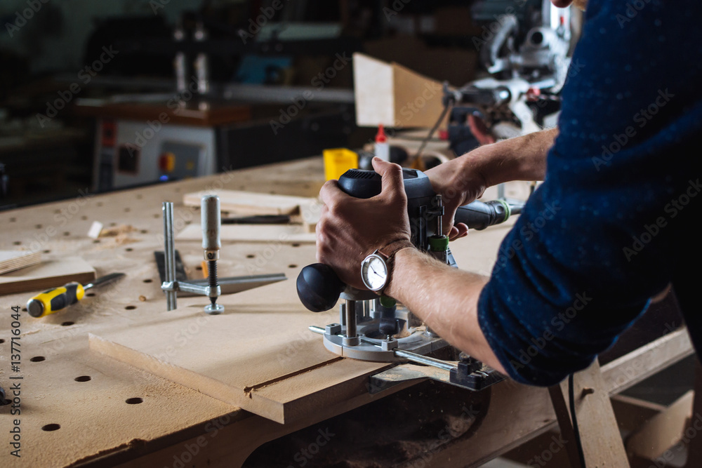 Young man working as carpenter and cutting board