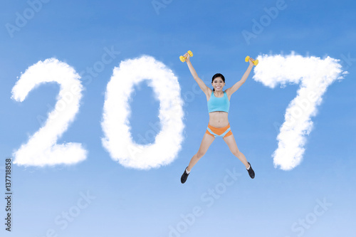Fit woman jumping with 2017