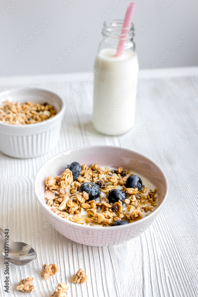 Homemade fitness granola with yoghurt and berries on white kitchen background Homemade fitness granola with yoghurt and berries on white kitchen background