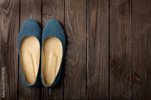 Blue women's shoes (ballerinas) on wooden background.