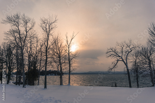 sun setting over lake in winter 