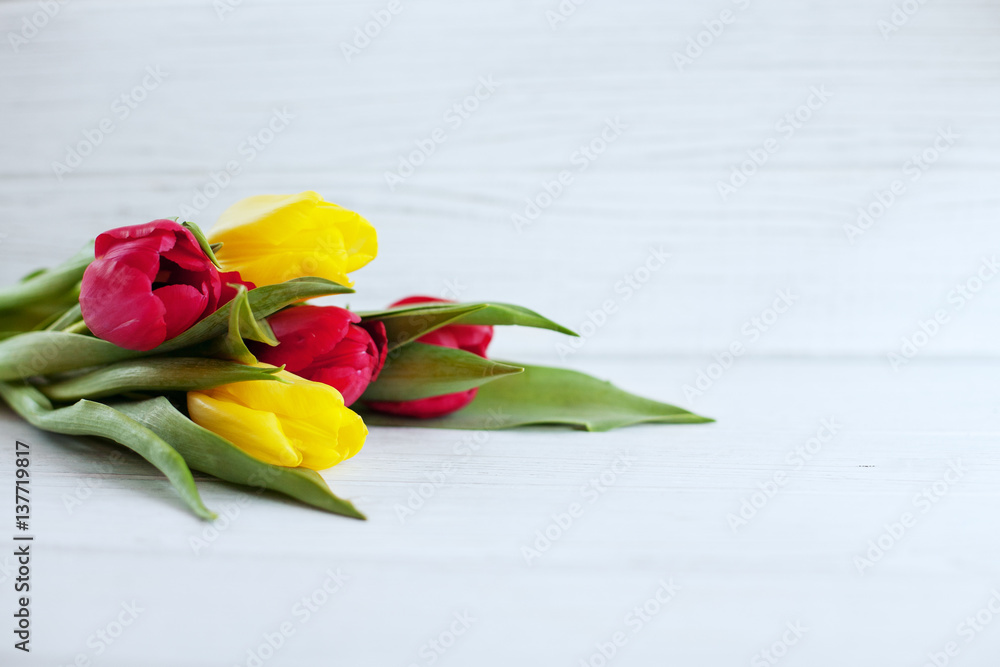 Wooden white background and yellow and red flowers. Conception holiday, March 8, Mother's Day. Wooden white background and yellow and red flowers. Conception holiday, March 8, Mother's Day.