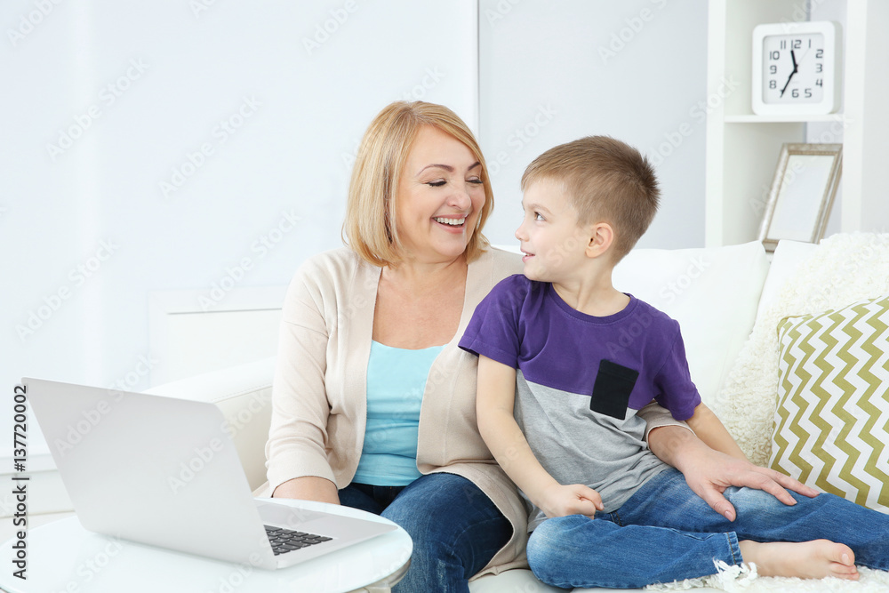 Grandmother and her grandson using laptop at home Grandmother and her grandson using laptop at home