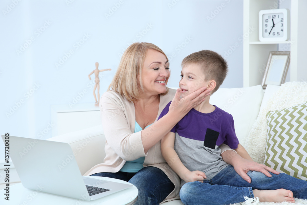 Grandmother and her grandson using laptop at home Grandmother and her grandson using laptop at home