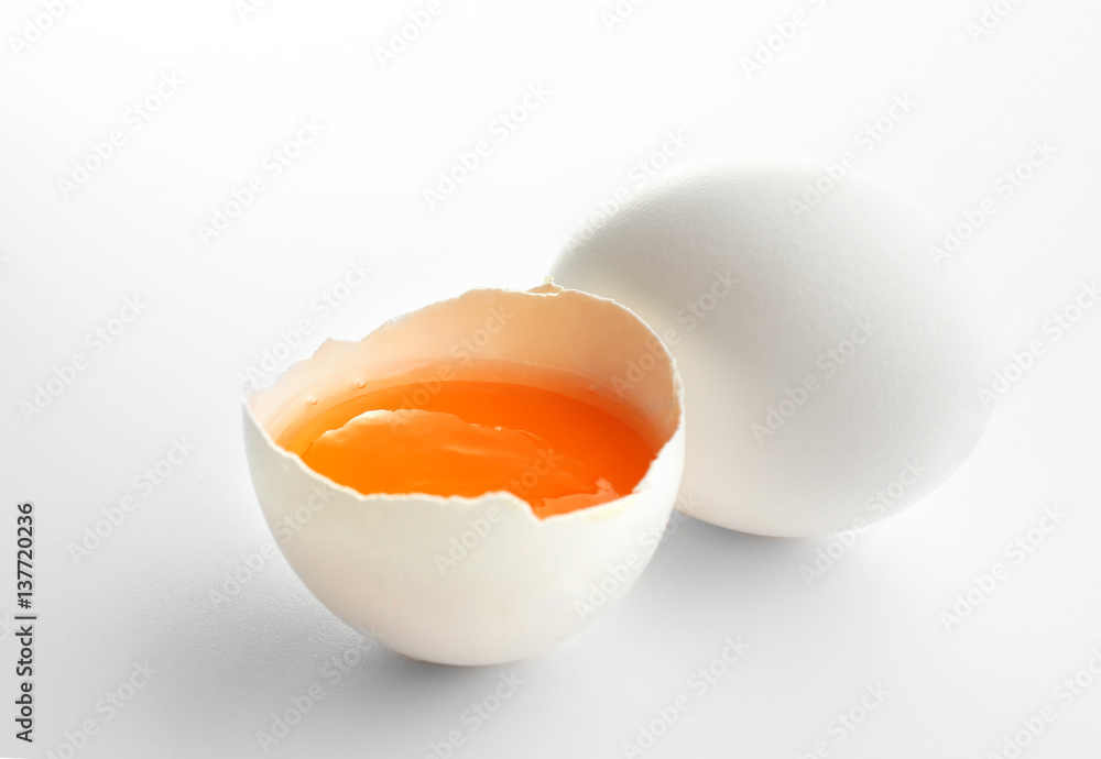 Raw egg with yolk on white background Raw egg with yolk on white background