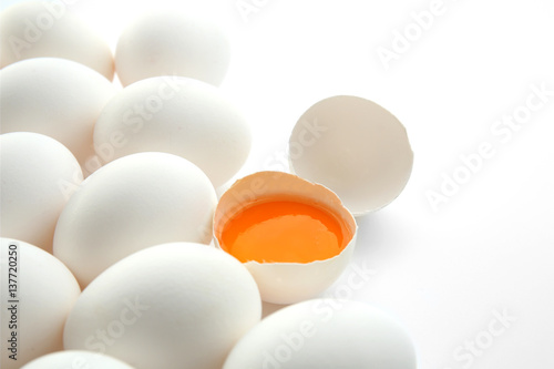 Raw eggs with yolk on white background