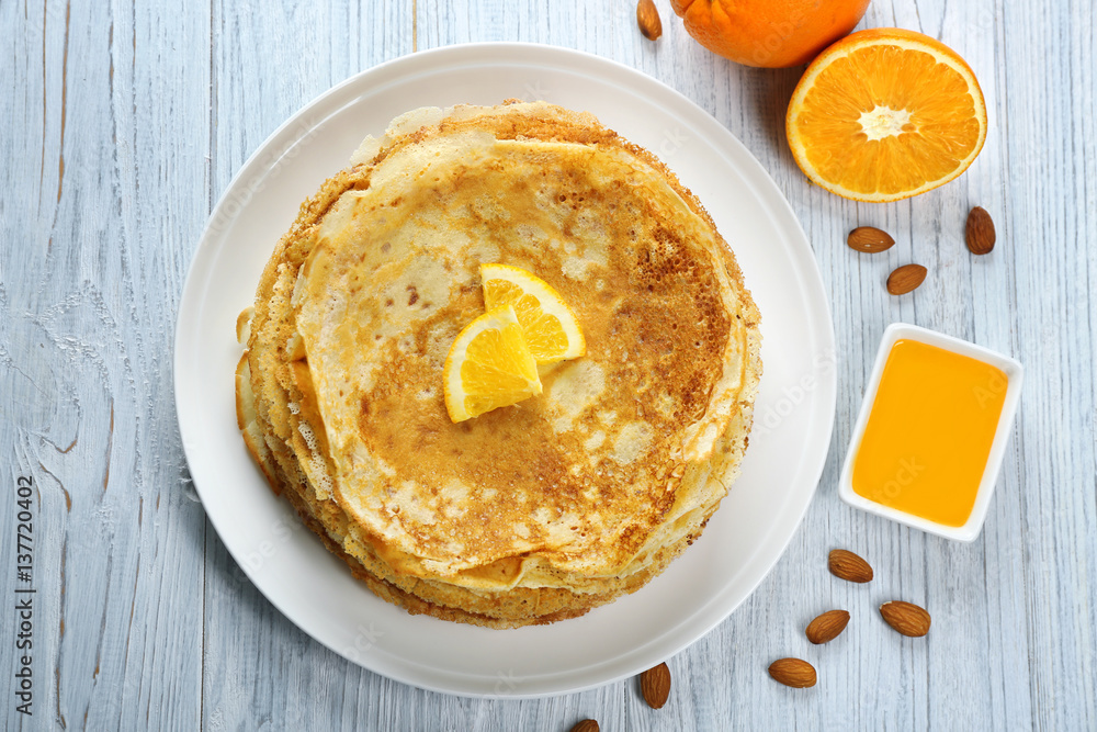 Stack of delicious pancakes with orange on wooden table Stack of delicious pancakes with orange on wooden table