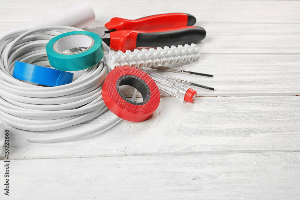 Electrician tools on white wooden background Electrician tools on white wooden background