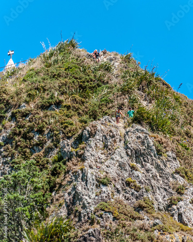 People climbing down Paritutu Rock. photo