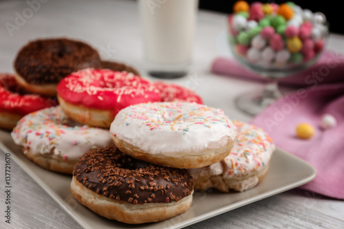 Plate with tasty donuts on table