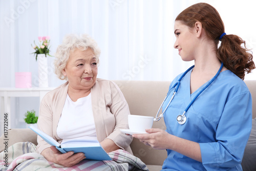 Nurse giving cup of tea to ...