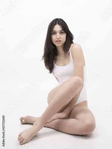 .Thin model of dark hair in white swimsuit