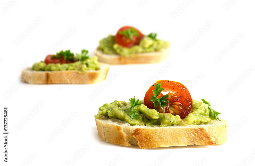 canapes with avocado cream or guacamole and tomatoes isolated on a white background, healthy party sandwiches, closeup canapes with avocado cream or guacamole and tomatoes isolated on a white background, healthy party sandwiches, closeup