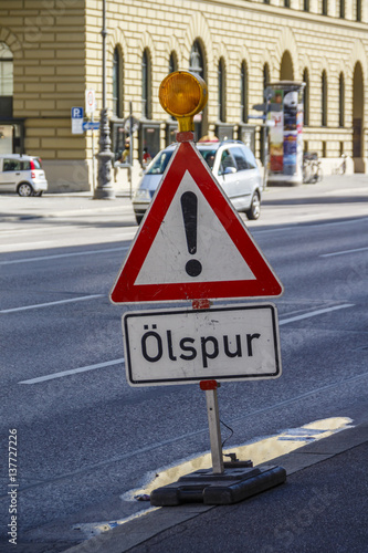 Warning sign regarding oil on the road in Munich, Germany, 2015