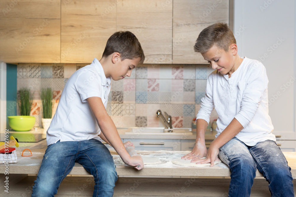 Two children having fun baking in the kitchen, Two brothers playing in kitchen Two children having fun baking in the kitchen, Two brothers playing in kitchen