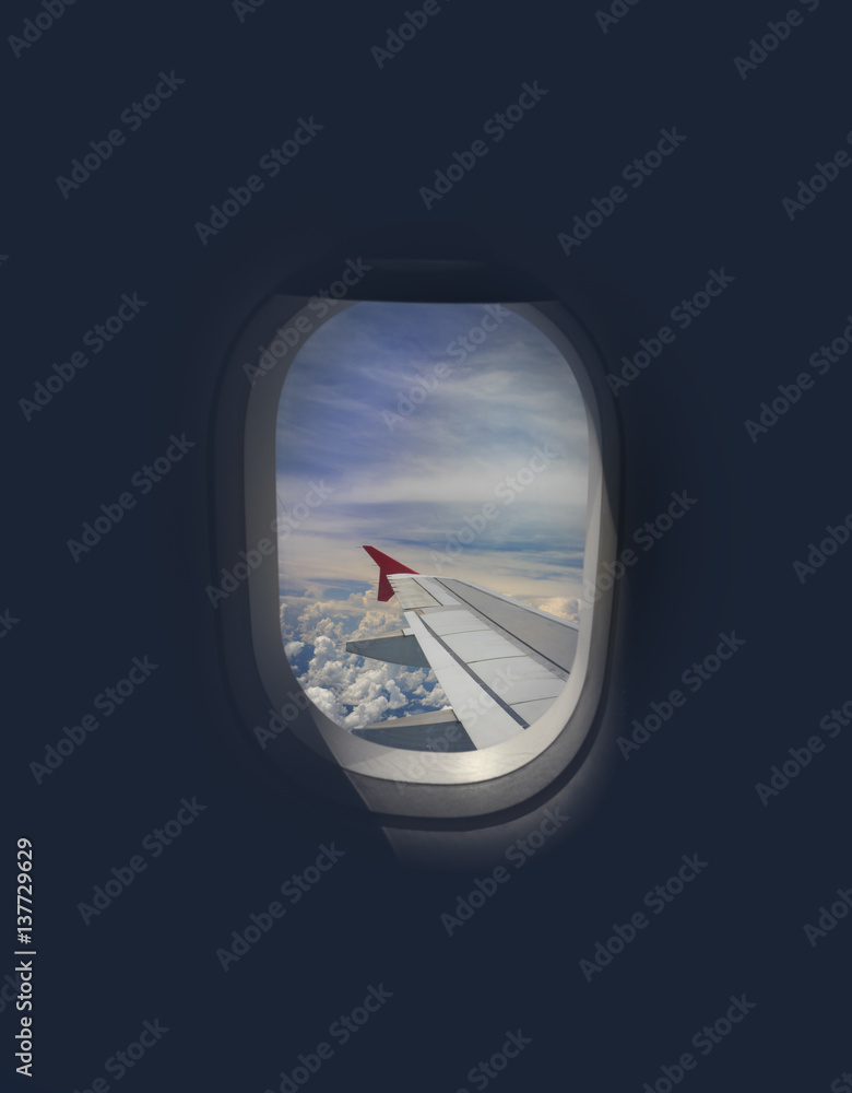 Wing of an airplane flying above the city. The view from an airplane window. Cloudy and color sky with sunlight. Photo applied to tourism operators. Traveling world concept.