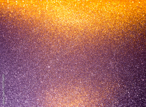 Abstract background filled with shiny gold and purple glitter