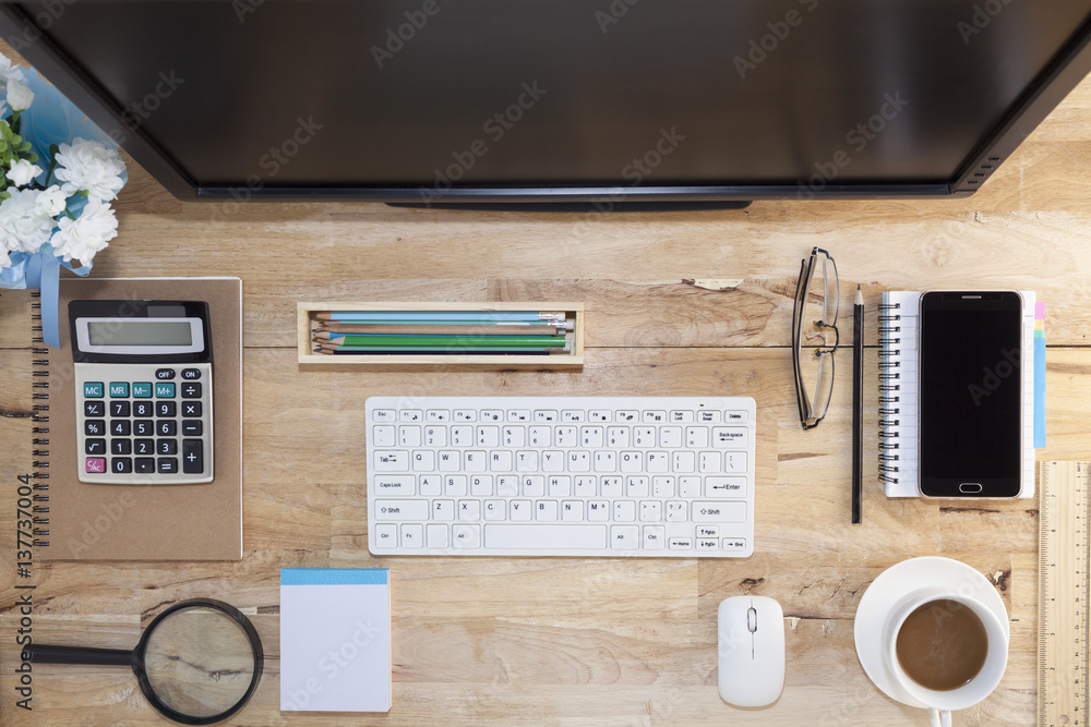 Top view with wood table, computer with keyboard,paper note,pencil,airplane model,flower,smartphone and coffee cup. Top view with wood table, computer with keyboard,paper note,pencil,airplane model,flower,smartphone and coffee cup.