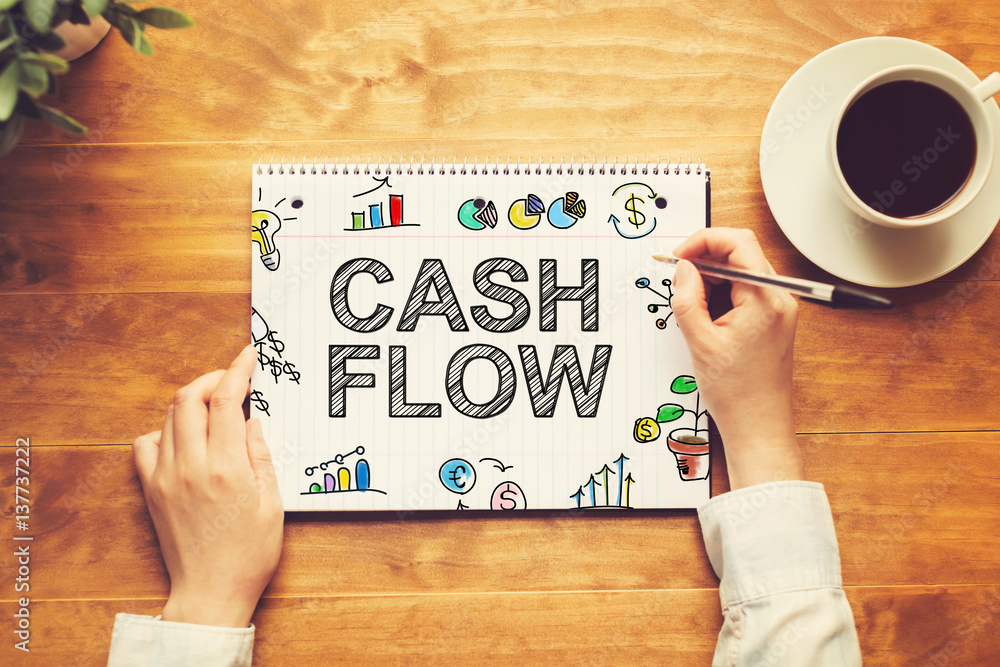 Cash Flow text with a person holding a pen Cash Flow text with a person holding a pen