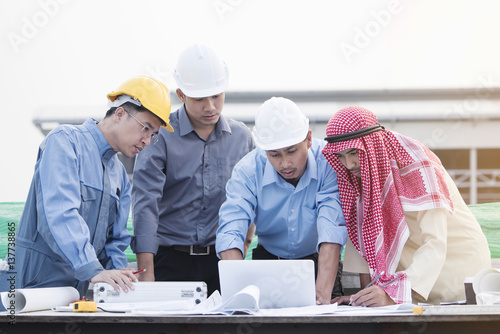 Asian engineers were consulted together and plan in construction site