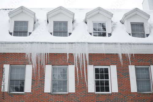 close up on old apartment building roof after snow with icicle © nd700
