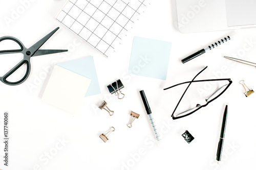 White office desk frame with paper blank and supplies. Laptop, notebook, pen, clips, glasses and office supplies on white background. Flat lay, top view, mockup.