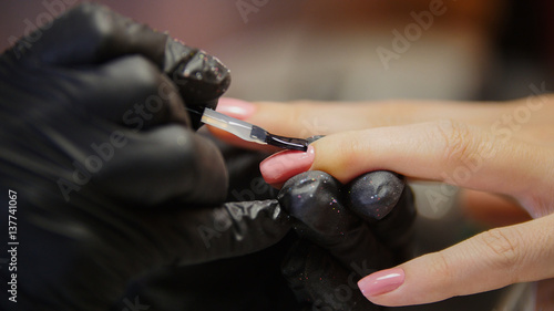 Macro view of polishing nails - female get professional manicure in beauty shop