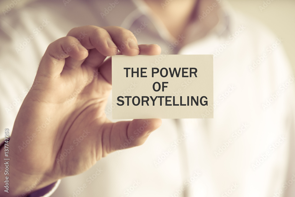 Businessman holding THE POWER OF STORYTELLING message card