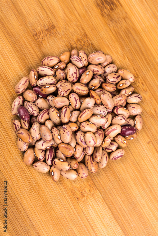 Organic cranberry beans isolated on a wood background