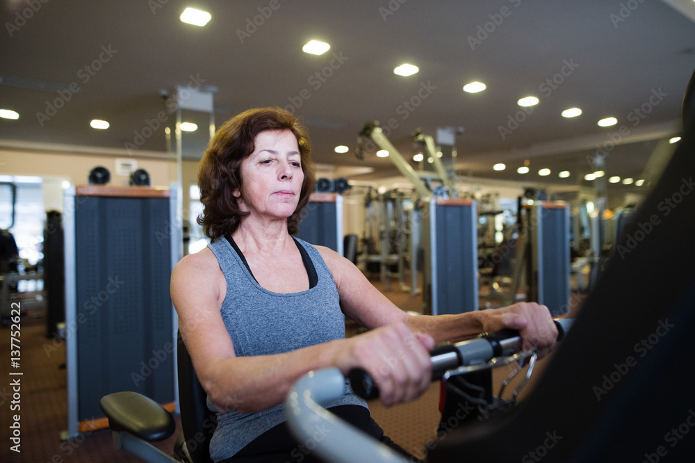 Beautiful fit senior woman in gym doing cardio work out. Beautiful fit senior woman in gym doing cardio work out.