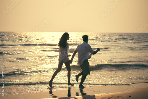 Couples holding hands Beach romp happily.