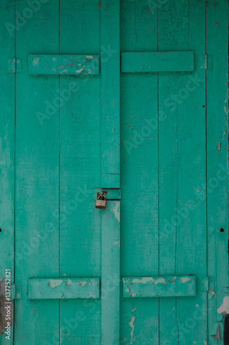 Old faded green shutters locked closeup grunge