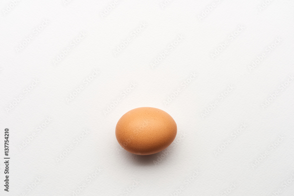 Single simple brown egg on white background Single simple brown egg on white background