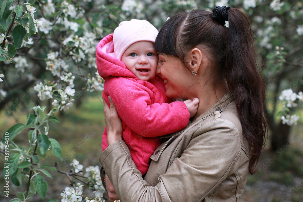 girl with daughter in a spring apple garden