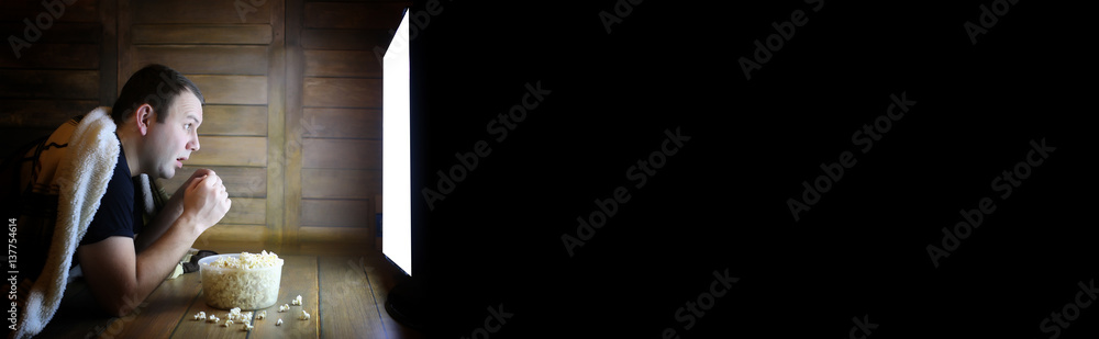 Naklejka premium man watching television at home on the floor