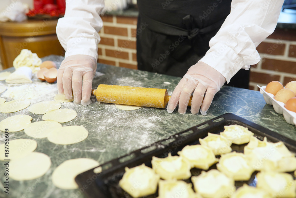 Male chef uses ingredients for preparing flour products on kitchen table Male chef uses ingredients for preparing flour products on kitchen table