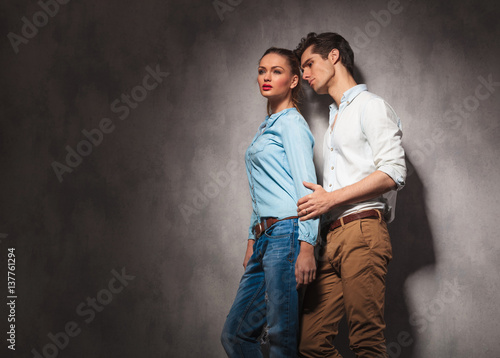side view of a young casual couple looking away