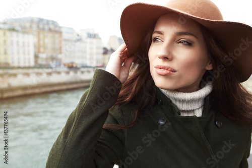 beautiful woman in a hat watching the view over the river Seine