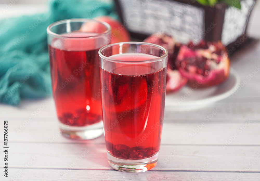 A glass of ripe pomegranate juice on wooden background. Healthy living concept A glass of ripe pomegranate juice on wooden background. Healthy living concept