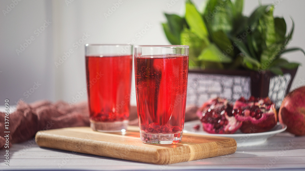 Pomegranate juice in a glass and ripe pomegranate Pomegranate juice in a glass and ripe pomegranate
