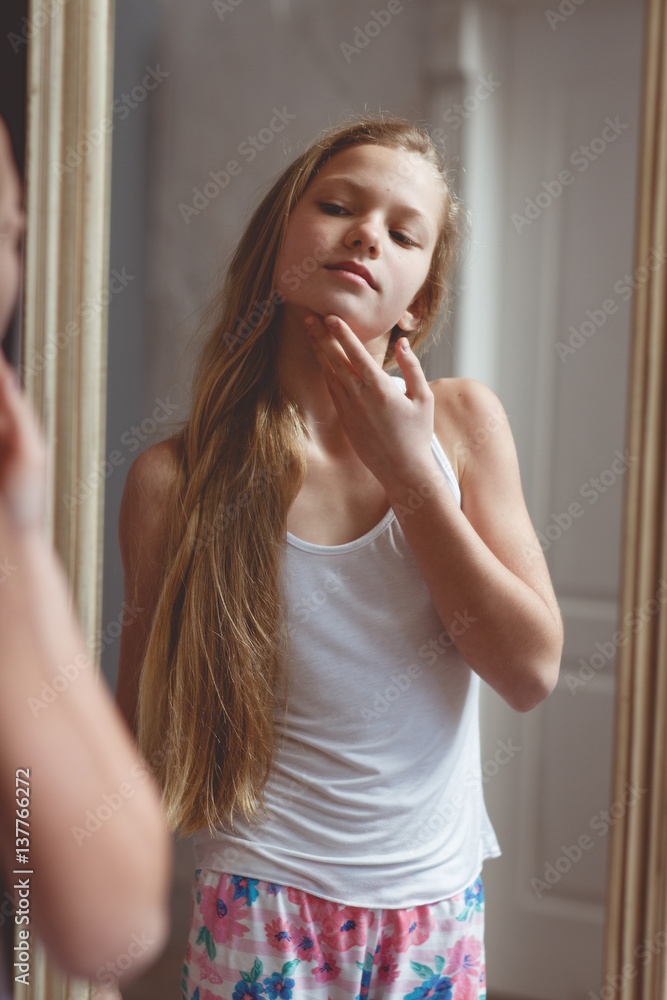 Teenage girl checking her face and body in the mirror Stock-foto | Adobe  Stock