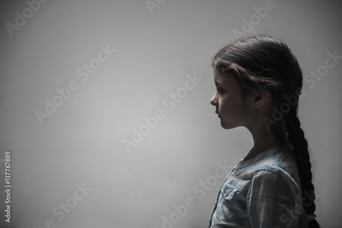 Portrait of little poor girl posing in profile