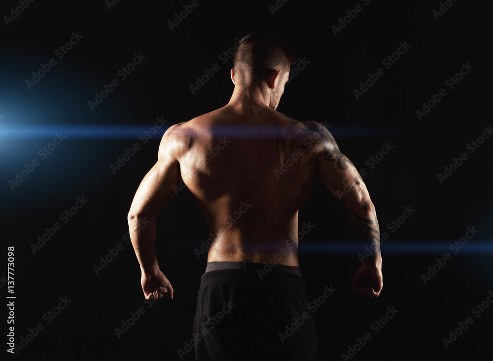 Unrecognizable man shows strong back muscles closeup Unrecognizable man shows strong back muscles closeup