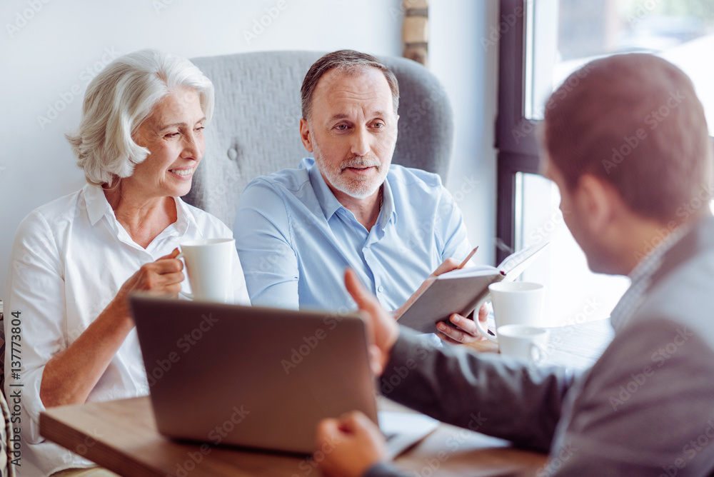 Positive aged couple consulting with insurance agent