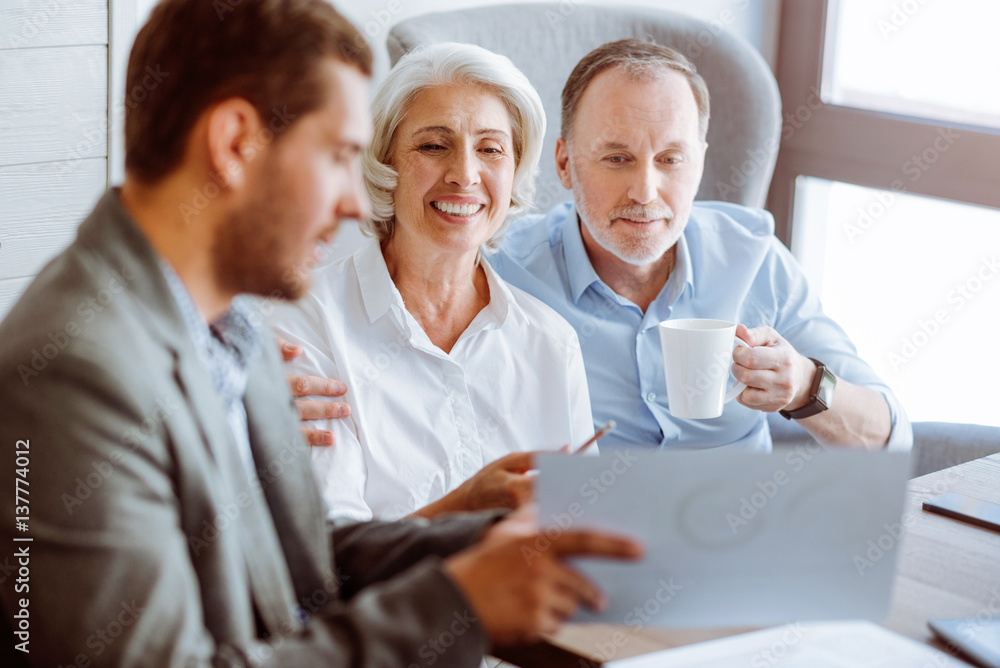 Positive aged couple meeting with insurance agent Positive aged couple meeting with insurance agent
