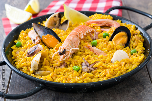 Traditional spanish seafood paella on wooden background 