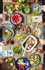 Hands of buddies eating vegetarian food by dinner